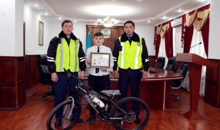 "Разрулившему" пробку шымкентскому школьнику полицейские подарили книгу о ПДД
